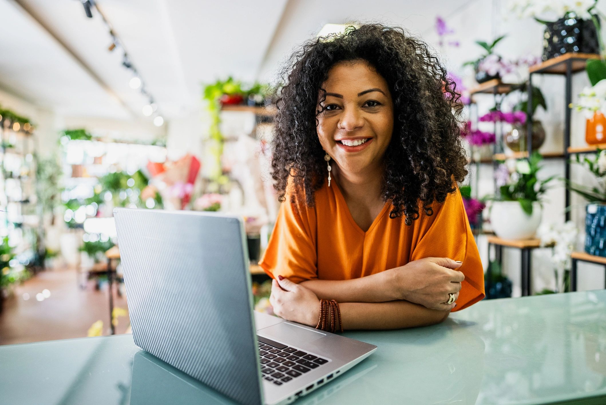 Small business owner working confidently with laptop in shop